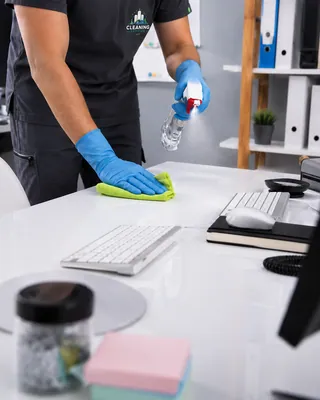 Cleaner wiping an office desk